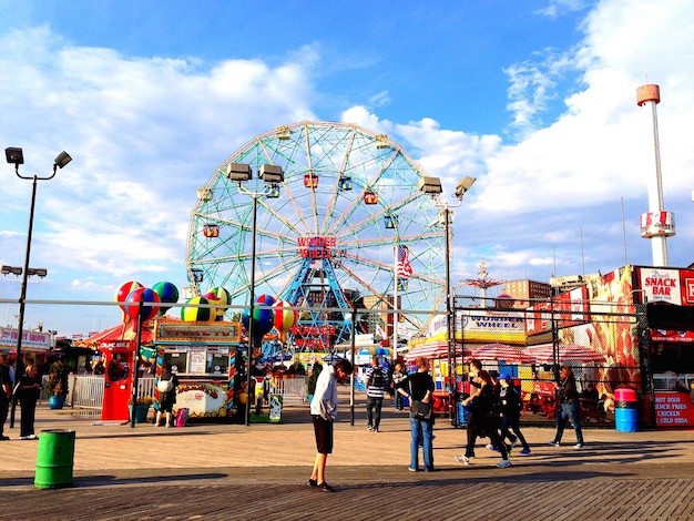 La rueda gigante en Coney Island contra el cielo con paseo marítimo