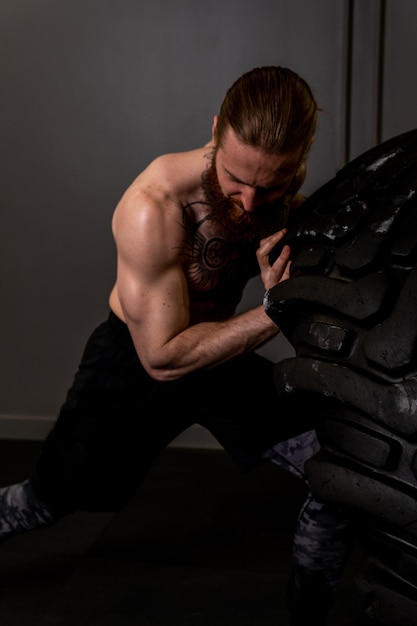 Rueda de neumático de gimnasio muscular fitness volteando hombre hombre ABS ejercicio concepto entrenamiento peso de ajuste