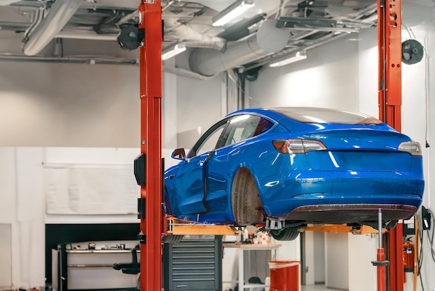 Rueda quitada Mantenimiento del vehículo eléctrico en un taller profesional Reparación del transporte EV El coche levantado en el taller de automoción El buje trasero de un coche sin rueda