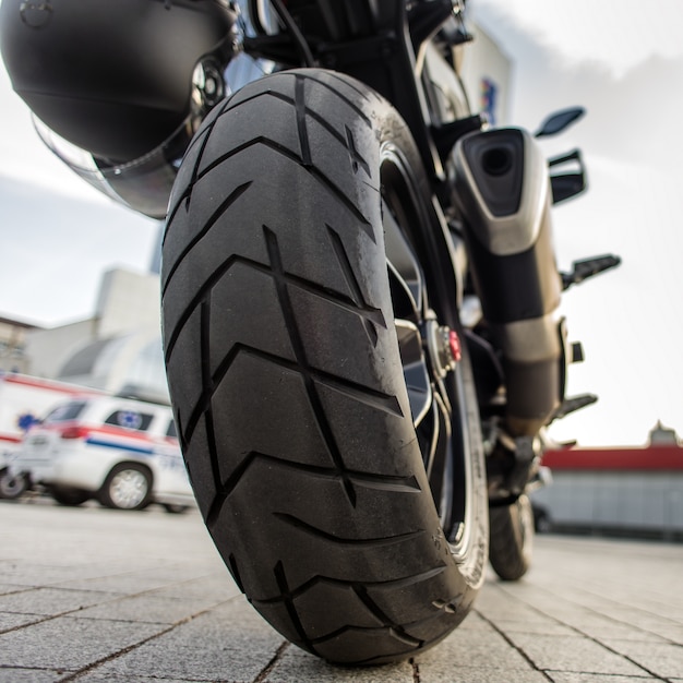 Rueda trasera de la motocicleta roja en la calle de la ciudad