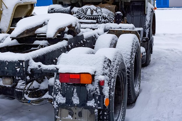 Las ruedas y el bastidor del tractor están cubiertos de nieve. Avería del automóvil con mal tiempo.