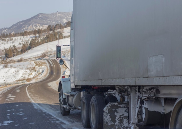 Ruedas de camión a toda velocidad en una carretera helada durante la tormenta de invierno