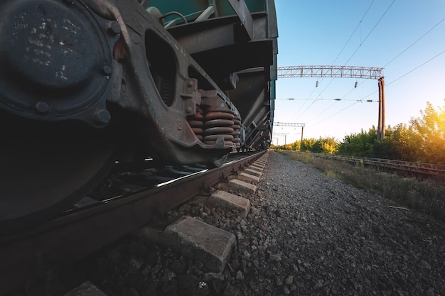 Foto ruedas de un tren ferroviario sobre rieles de cerca, transporte de carga