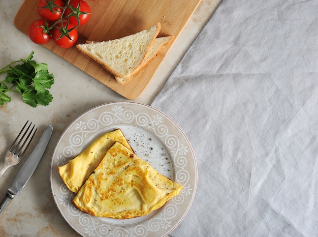 Rührei auf einer Platte, einer Petersilie, Tomaten, einem Toast und einer Textilserviette