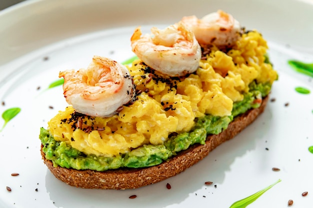 Rührei auf Toast mit Guacamole-Garnelen und Oliven