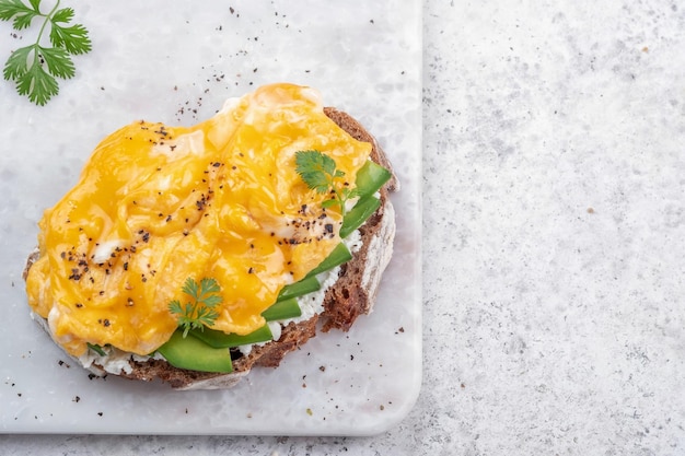 Rührei mit Avocado und Frischkäse auf Toast Frühstücksgericht