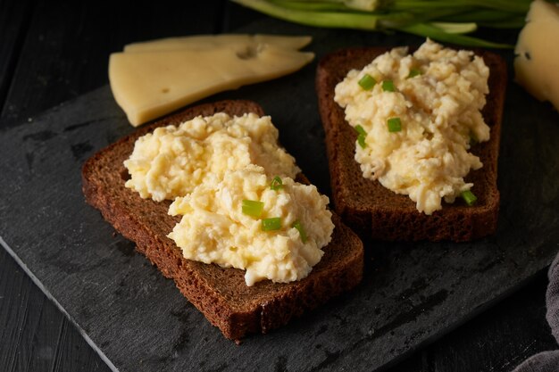 Rührei mit Frühlingszwiebeln mit glutenfreiem Brot auf dem Tisch