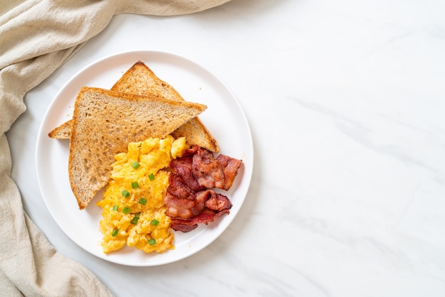 Rührei mit geröstetem Brot und Speck zum Frühstück