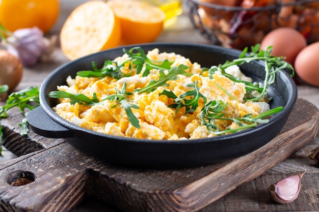 Rührei mit Mais, Frischkäsesauce, Kräutern und Gemüse in gusseiserner Pfanne. Leckeres hausgemachtes Frühstück