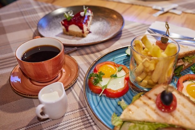 Rührei-Sandwich mit Frischkäse auf Roggen-Toast zum Frühstück auf weißem Hintergrund Gesundes Frühstück oder Snack