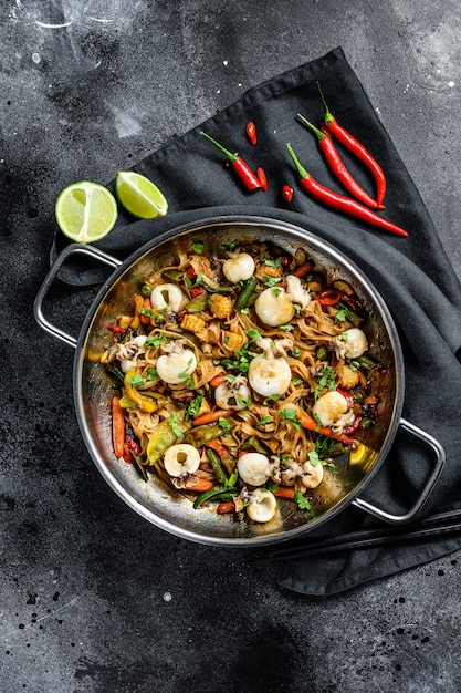 Foto rühren sie braten nudeln mit meeresfrüchten und gemüse in einer wok-pfanne