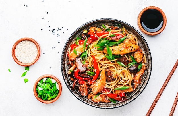 Rühren Sie Eier-Nudeln mit Hühner, süßen Paprika, Pilzen, Pfeifen und Sesamkörnern in einer Schüssel.