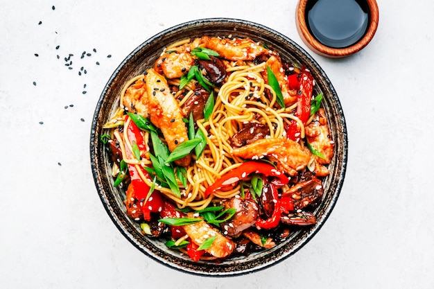Rühren Sie Eier-Nudeln mit Hühner, süßen Paprika, Pilzen, Pfeifen und Sesamkörnern in einer Schüssel.