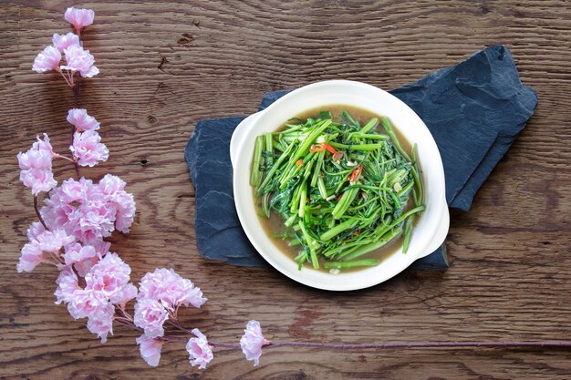Rühren Sie gebratenes Wasser, Spinat oder Pak Boong Fai Daeng auf einem weißen Teller.