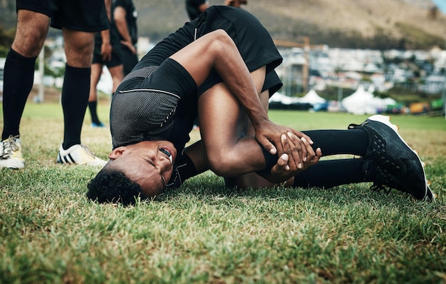 El rugby es un deporte que viene con muchas lesiones Captura recortada de un apuesto joven jugador de rugby que sufre una lesión en el campo