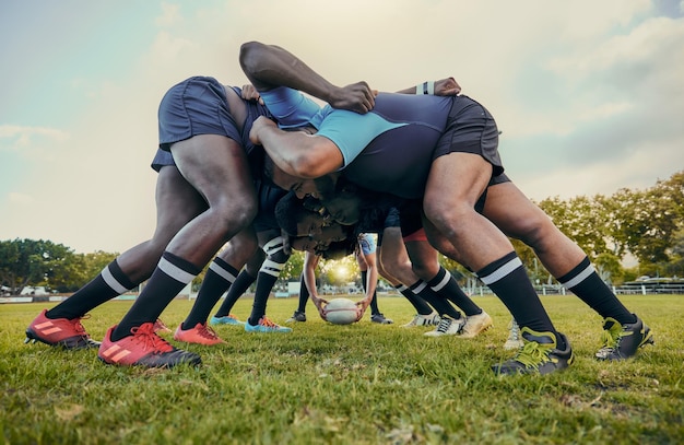 Foto rugby-fitness-scrum oder männertraining im stadion auf dem rasenplatz beim spieltraining oder sportspiel. teamwork-ball oder starke athleten bei tackle-übungen, leistung oder training im gruppenwettbewerb