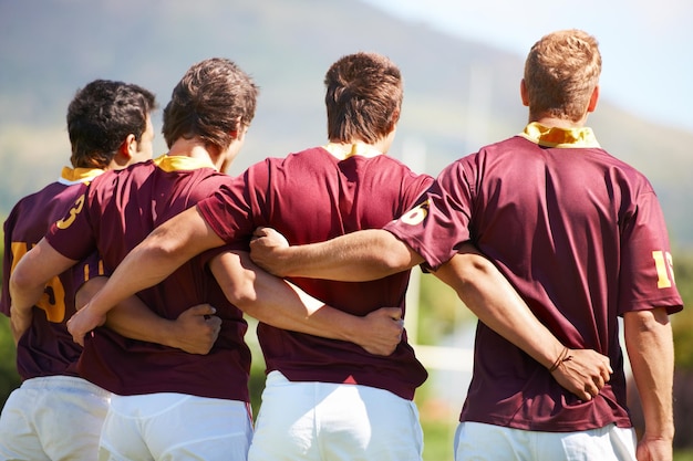 Rugby-Mannschaft und Sport mit Männern in einer Reihe draußen auf einem Feld vor einem Spiel oder Wettkampf im Sommer. Teamwork-Sport und Einheit mit männlichen Athleten oder Spielern, die sich auf das Training oder ein Spiel vorbereiten