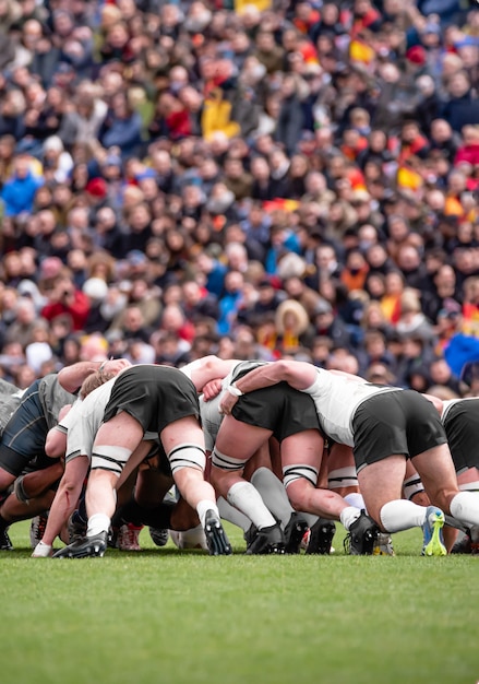 Rugby-Team in einer Teamumarmung mit verschwommenen Zuschauern