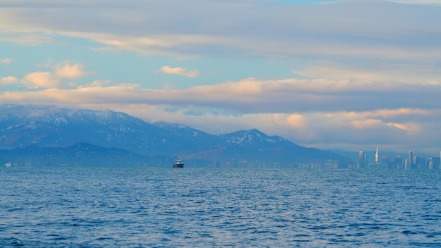 Ruhig schwarzes Meer Wolkenkratzer am Ufer der Bucht das Fischerschiff ging ins Meer, um zu fischen