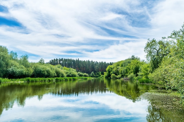 Ruhige Landschaft mit blauem Fluss und grünen Bäumen