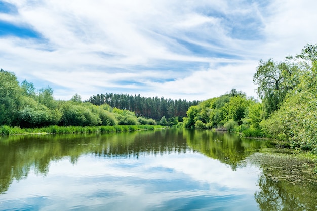 Ruhige Landschaft mit blauem Fluss und grünen Bäumen