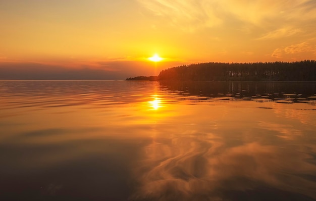 Ruhige wolke der goldenen stunde über dem waldsee bei sonnenuntergang dramatische wolkengebilde symmetriereflexionen auf dem natürlichen spiegel des wassers wasserkräuselung sonnenuntergang hintergrund