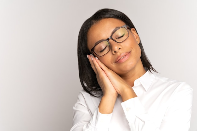 Ruhiger afroamerikanischer Geschäftsfrauschlaf auf gefalteter Hand liegend mit geschlossenen Augen erschöpft müde bei der Arbeit