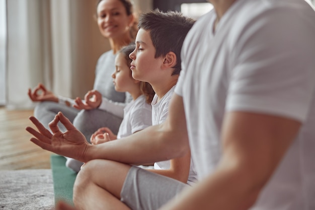 Ruhiger kleiner Junge, der drinnen Meditation mit der Familie genießt