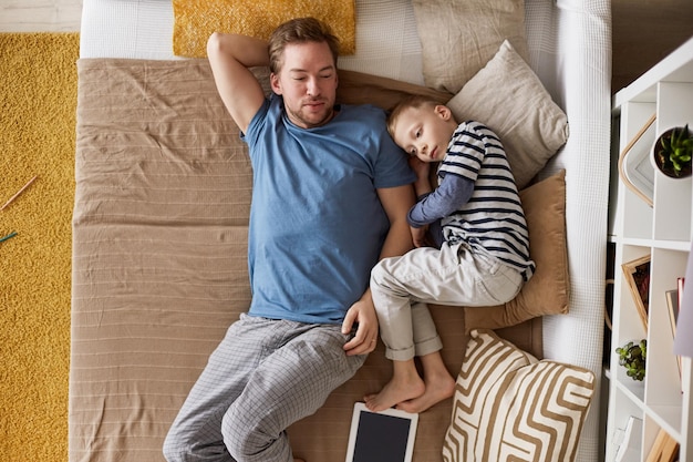 Ruhiger Vater und Sohn, die auf dem Schlafsofa liegen