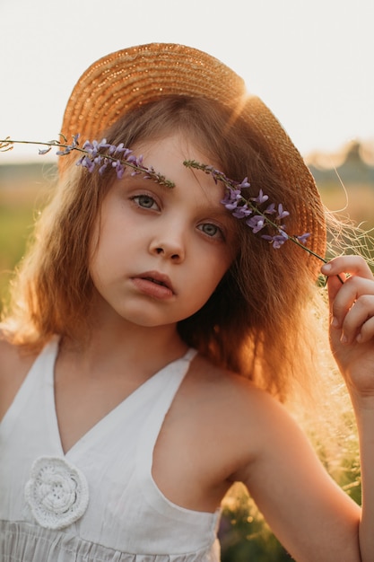 Ruhiges Mädchen mit schönen Blumen auf dem Feld im Sommer