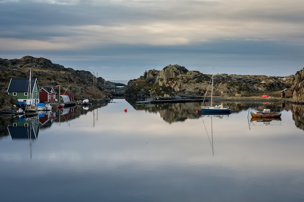 Ruhiges Meer mit Booten und Bootshäusern, schöne Landschaft und Himmel. Der Rovaer-Archipel.