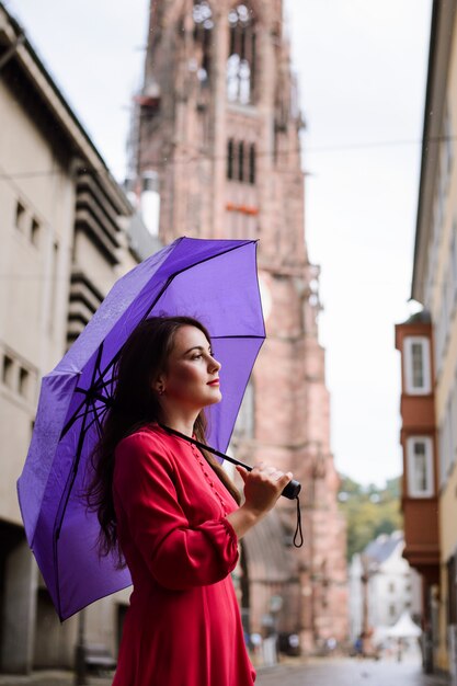 Ruhiges träumendes Mädchen, das einen Spaziergang in der Stadt während des Regens hat