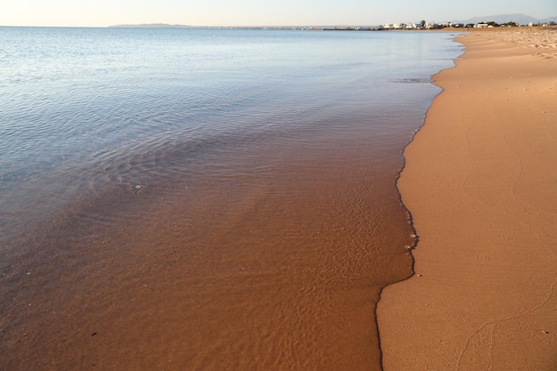 Ruhiges transparentes Meer und der Sandstrand