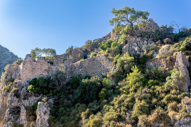 Ruinas de antiguas murallas de la fortaleza en las laderas de las montañas rocosas cerca de la antigua ciudad de Olimpo, Turquía