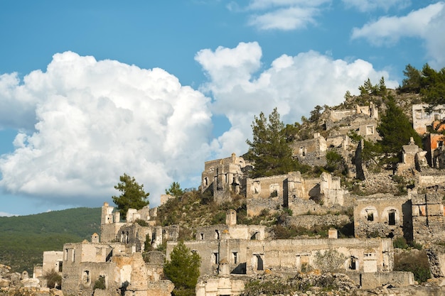 Las ruinas de la ciudad griega abandonada de Levissi cerca del pueblo de Kayakoy en Fethiye Turquía contra el telón de fondo de las nubes cúmulos la tragedia de las guerras Sitio de la antigua ciudad de Karmilissos