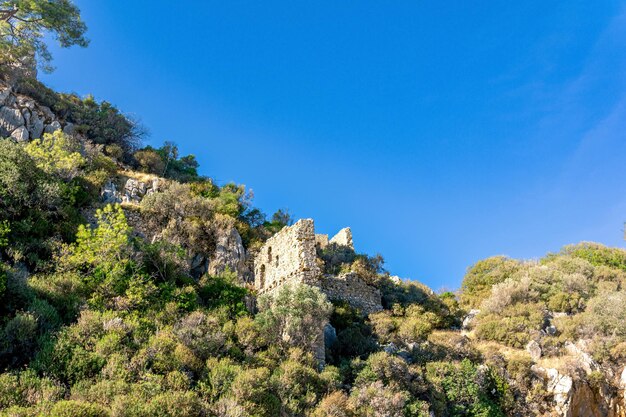 Ruínas de antigas muralhas nas encostas de montanhas rochosas perto da antiga cidade de Olimpo, na Turquia