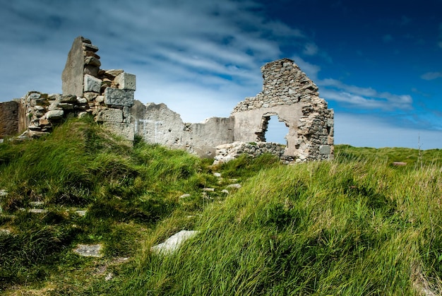 Ruínas de um edifício entre as gramíneas da costa de Ile Grande no norte da Bretanha