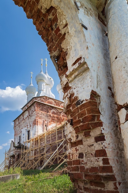 Ruínas de uma Igreja Ortodoxa Russa com paredes de tijolos à luz do dia, vila de Dunilovo, Rússia