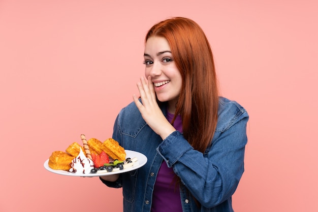 Ruiva adolescente mulher segurando waffles sussurrando algo