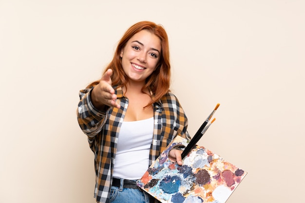 Ruiva adolescente segurando um aperto de mão paleta depois de um bom negócio