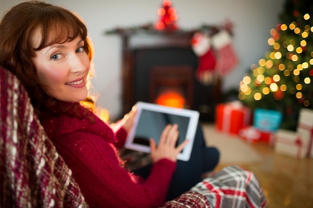 Ruiva de beleza usando tablet no Natal em casa na sala de estar