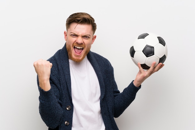 Ruiva homem segurando uma bola de futebol