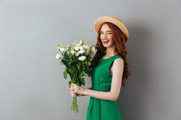 Ruiva jovem alegre com flores.