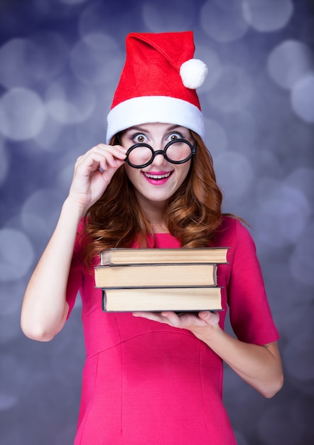 Ruiva no chapéu de Natal com livros