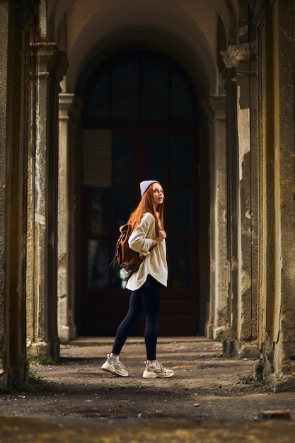 Ruiva turista feminino destino de viagem visitando lugar antigo abandonado de férias bela mulher w ...