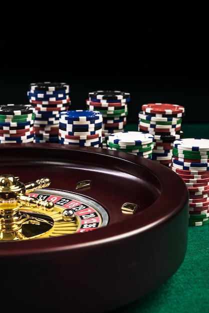 Ruleta con pilas de fichas de casino Juegos de azar o fondo de casino