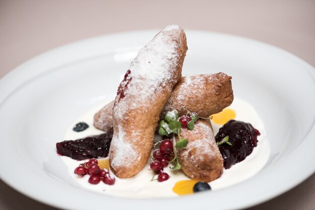 Rumänische traditionelle Süßigkeiten - Käsepfannkuchen mit Sauerrahm, Marmelade und mit Waldfrüchten verziert