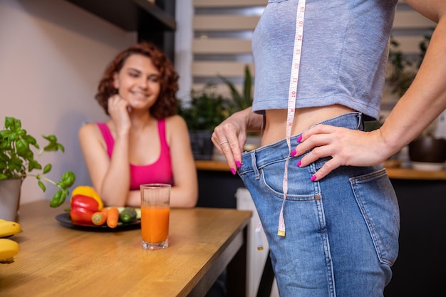 Rumpf einer Frau, der im Profil sichtbar ist, verschwommene Figur eines Mädchens im Hintergrund