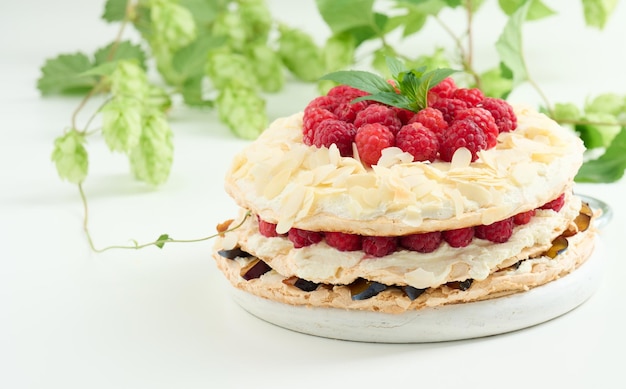 Runde Baiser-Torte mit frischen Himbeeren auf weißem Hintergrund Pavlova-Dessert