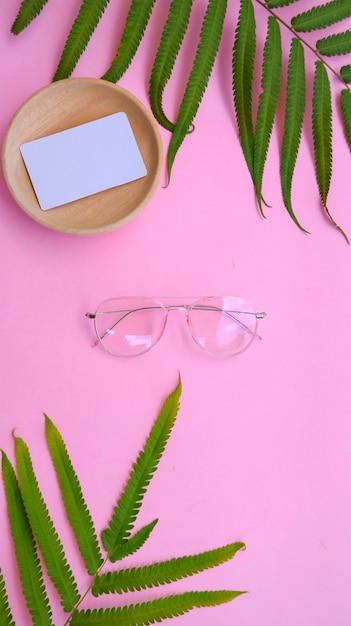 Runde Brille auf dem Foto im minimalen Sommerstil auf pastellrosafarbenem Hintergrund.